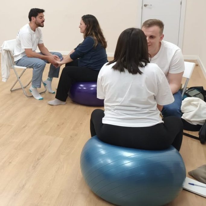 hipnoparto Madrid Embarazadas y su acompañantes se sientan en pelotas de ejercicios, trabajan herramientas de preparación al parto.